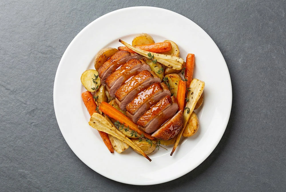 Pan seared duck breast with a delicate water, butter, and sugar glaze, served with a vibrant root vegetable medley.